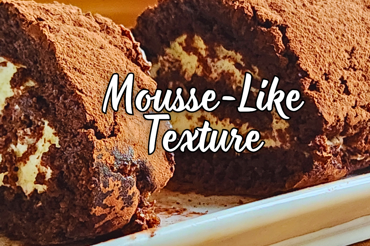A rich, chocolate mousse-like flourless cake rolled into a log with cocoa dusting.