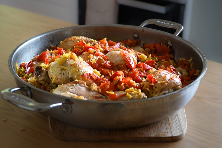 A serving of French chicken pilaf with golden chicken, seasoned rice, and capsicum & tomato.