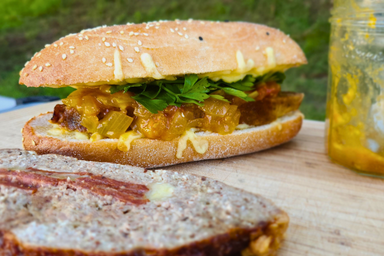 Sliced cheese-stuffed meatloaf served in a roll with parsley and relish.