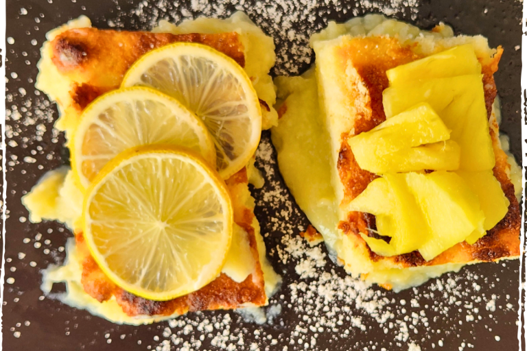 Overhead view of lemon and pineapple delicious puddings topped with fresh fruit slices
