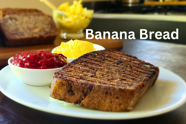 Toasted banana bread on a plate with jam and butter, labelled with "Banana Bread"