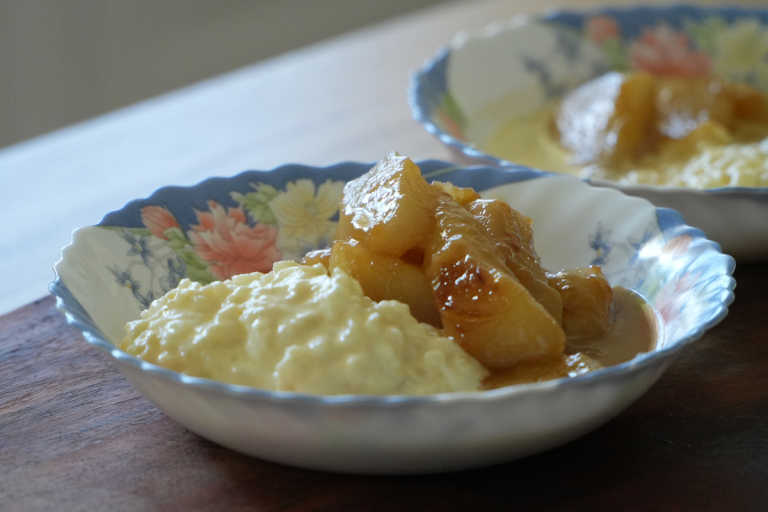 Creamy rice pudding served with caramelised pears in a vintage floral dessert bowl.