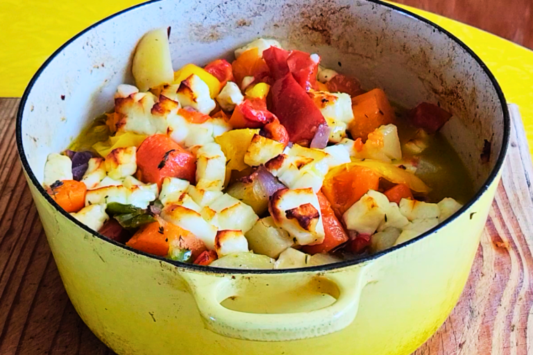 Roasted vegetables with golden halloumi cheese in a yellow enamel pot