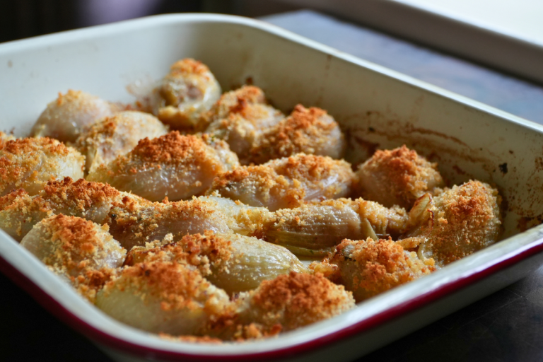 Tray of baked Swedish stuffed onion rolls with golden breadcrumb topping