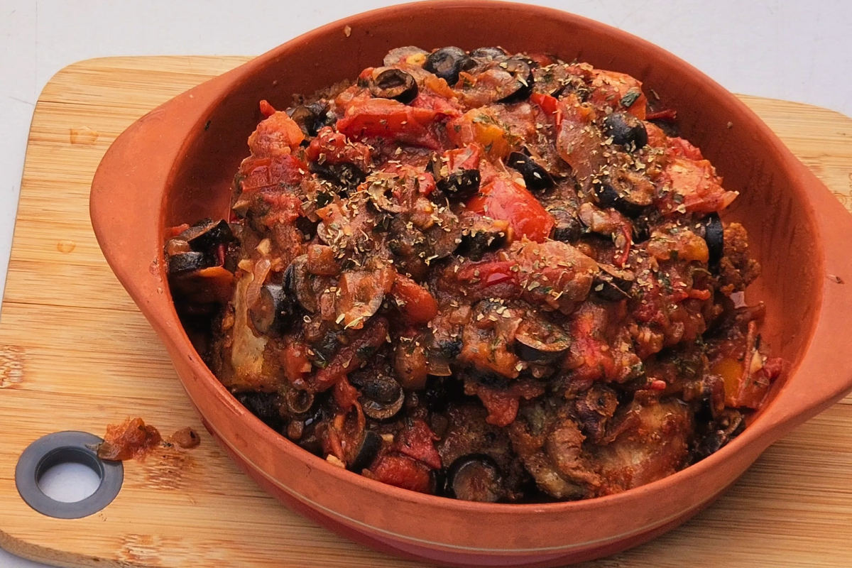 Golden sautéed chicken topped with rustic Provençal tomato, olive, and herb sauce in a terracotta dish