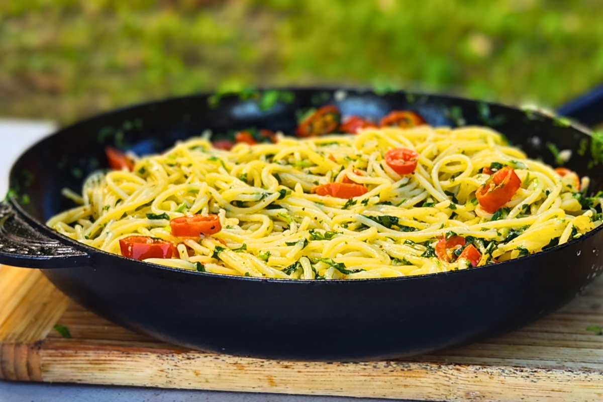 Quick pasta with garlic, chilies, and parsley in a black pan