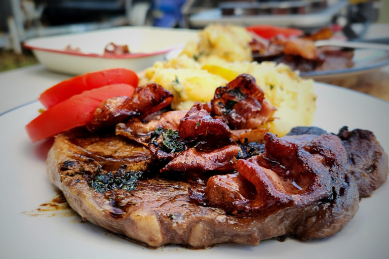 Portuguese steak topped with crispy prosciutto, served with Salsa Verde potatoes and fresh tomato slices