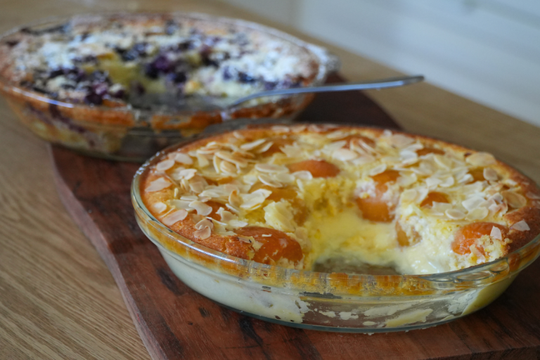 Apricot almond impossible pie in a glass pie dish, topped with flaked almonds