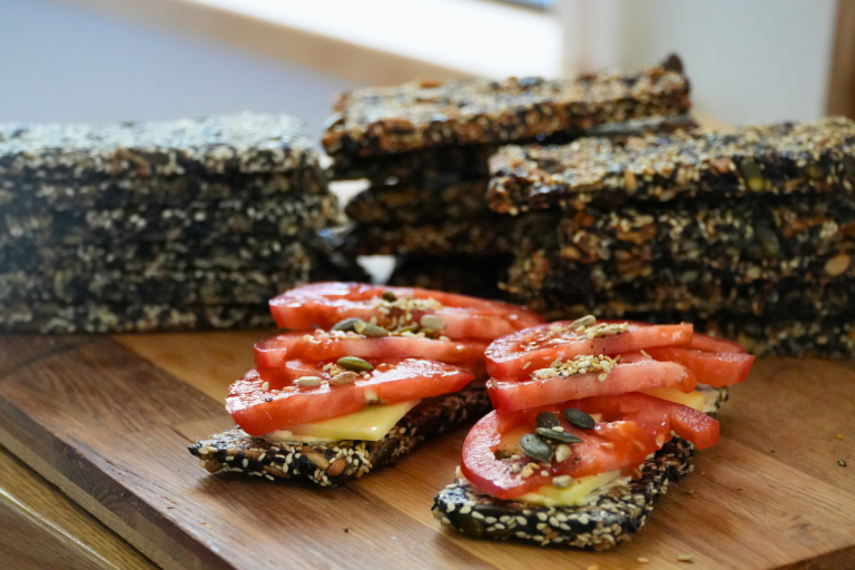 Easy seed crackers – gluten-free and vegan, served with tomato and cheese.