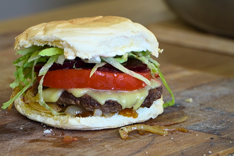 Good old-fashioned hamburger with homemade beef patty, cheese, tomato, beetroot and lettuce on a soft bun