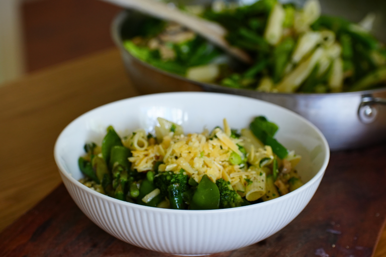 Fresh pasta primavera with green vegetables served in a white bowl