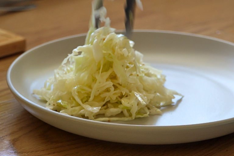 Plated serving of homemade cabbage salad on a white plate.