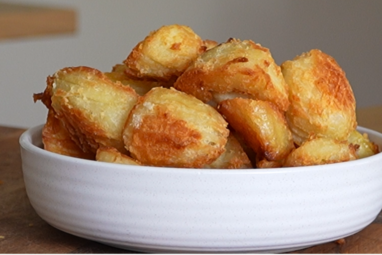 Close up of crispy roast potatoes with golden crunchy edges and fluffy centres