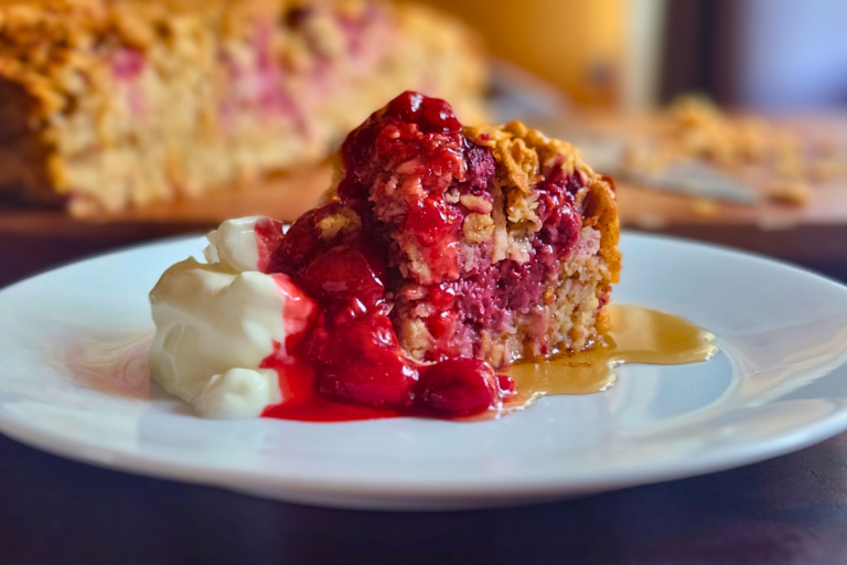 Easy baked oatmeal with apple and berries served with berry coulis and yoghurt