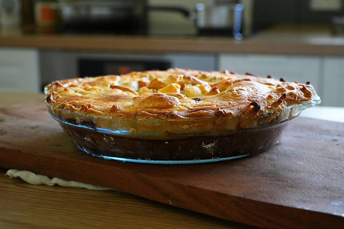 Homemade old-fashioned Aussie steak pie with golden puff pastry and rich beef filling