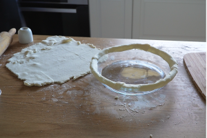 Pastry strips pressed around the rim of a pie dish ready for the steak pie filling and pastry lid